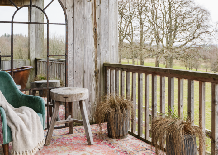 A green plush chair in an open seating area of a cabin in a resort hotel overlooking golf course.